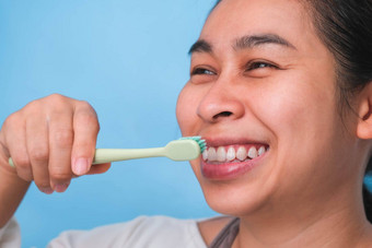 快乐亚洲女人采取护理牙齿持有牙刷年轻的夫人刷牙牙齿牙科护理口服卫生概念