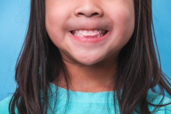 微笑可爱的女孩吃甜蜜的明胶糖<strong>添加</strong>孤立的蓝色的背景孩子们吃含糖的糖果导致损失牙齿牙衰变<strong>不</strong>健康的口服护理