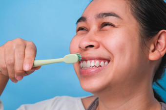 快乐亚洲女人采取护理牙齿持有牙刷年轻的夫人刷牙牙齿牙科护理口服卫生概念
