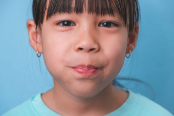 微笑可爱的女孩吃甜蜜的明胶糖添加孤立的蓝色的背景孩子们吃含糖的糖果导致损失牙齿牙衰变不健康的口服护理