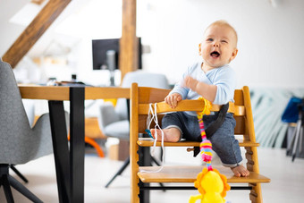 快乐<strong>婴</strong>儿坐着玩玩具传统的斯堪的那维亚设计师木高椅子现代明亮的atic<strong>首页</strong>可爱的<strong>婴</strong>儿