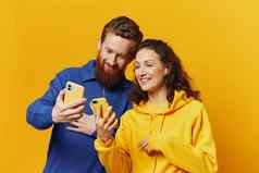 男人。女人夫妇微笑愉快地电话手社会媒体查看照片视频黄色的背景符号迹象手手势家庭自由职业者