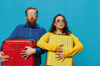 女人男人。微笑手提箱手黄色的红色的手提箱微笑有趣的蓝色的背景包装旅行家庭假期旅行