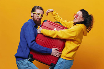 女人男人。微笑手提箱手黄色的红色的手提箱微笑愉快地弯曲的黄色的背景旅行家庭假期旅行新婚夫妇