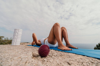 女人海普拉提运动快乐中年女人实践普拉提海滩海促进健康的生活方式户外健身冥想