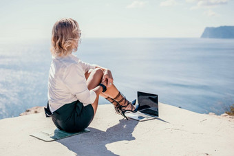 女人海移动PC业务女人黄色的他自由职业者移动PC工作蓝色的海海滩女孩缓解压力工作自由数字游牧旅行假期概念