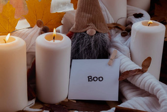 嘘文本问候卡概念庆祝万圣节秋天假期舒适的首页窗台上舒适审美大气秋天叶子Gnome香料蜡烛针织白色毛衣温暖的黄色的灯