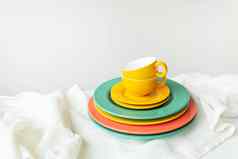 空黄色的杯明亮彩色的盘子白色表格覆盖亚麻桌布