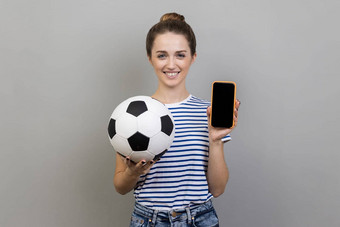 女人相机微笑持有<strong>足球</strong>球显示细胞电话黑色的空白屏幕