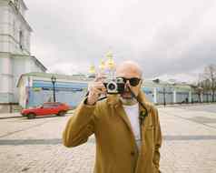 英俊的胡子摄影师使图片电影复古的相机基辅城市乌克兰