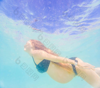 怀孕了女人水下游泳热带海健康的活跃的怀孕年轻的期待妈妈夏天海滩假期婴儿出生游泳假期水有趣的旅行怀孕水下摄影