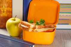 午餐盒子烤片面包奶酪绿色欧芹绿色苹果精装书背景
