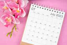7月日历桌子上粉红色的兰花粉红色的颜色背景