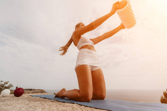 女人海普拉提运动中年女人练习普拉提公园海火车瑜伽席散发出快乐活跃的举止健康的生活方式锻炼冥想