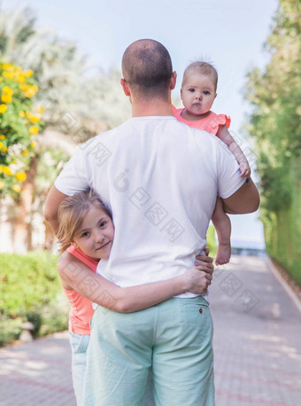年轻的父亲拥抱女儿花园