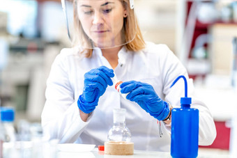 女人进行研究危险的化学物质生化实验室科学研究所保护设备玻璃脸面具橡胶手套