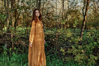 美丽的女人走阴影树穿着长橙色衣服享受天气周末摆姿势放松主题隐私自然