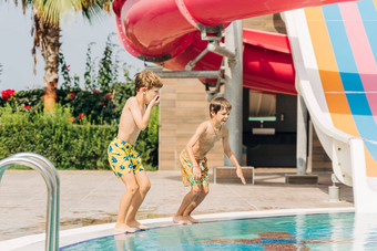 兄弟蔡尔兹跳玩游泳池阳光明媚的一天孩子们朋友男孩让人耳目一新热天气活跃的假期健康的生活方式快乐夏天