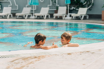 兄弟蔡尔兹笑玩游泳池阳光明媚的一天孩子们朋友男孩让人耳目一新热天气活跃的假期健康的生活方式快乐夏天