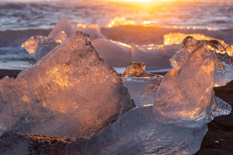 纯冰闪亮的黑色的火山沙子日落冰山冰川太阳射线清晰的冰海洋波著名的旅游位置北欧洲国家旅行目的地钻石海滩