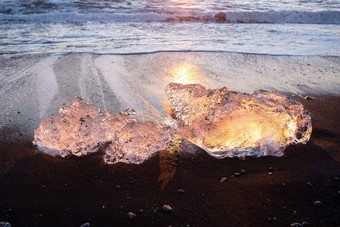 <strong>纯</strong>冰闪亮的黑色的火山沙子日落冰山冰川太阳射线清晰的冰海洋波著名的<strong>旅游</strong>位置北欧洲国家旅行目的地钻石海滩
