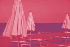 漂亮的充满活力的粉红色的海滩伞美丽的金沙子田园热带海滩概念上的夏天假期度假日光浴浴床阳伞海滩时尚的时尚颜色