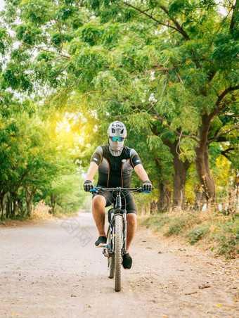 专业骑自行车的人污垢路脂肪骑自行车的人污垢路包围树生活方式胖乎乎的骑自行车的人路