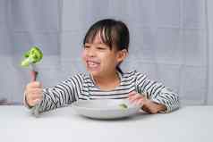 孩子们爱吃蔬菜可爱的亚洲女孩吃健康的蔬菜餐营养健康的吃习惯孩子们