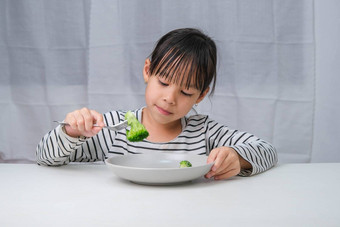 孩子们爱吃蔬菜可爱的亚洲女孩吃健康的蔬菜餐营养健康的吃习惯孩子们