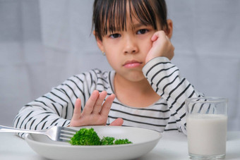 孩子们吃蔬菜可爱的亚洲女孩拒绝吃健康的蔬菜营养健康的吃习惯孩子们