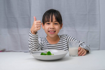 <strong>可爱</strong>的亚洲女孩喝玻璃牛奶早....学校女孩吃健康的<strong>蔬菜</strong>牛奶餐健康的食物童年