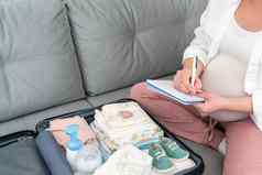 怀孕了女人写作包装列表孕妇医院坐着沙发上手提箱