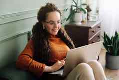 年轻的女人享受在线购物网络学习移动PC首页首页购物网络学习快乐女人移动PC沙发