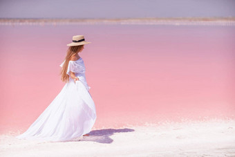 女人粉红色的盐湖白色衣服他享受风景优美的视图粉红色的盐湖走白色咸海岸创建持久的内存