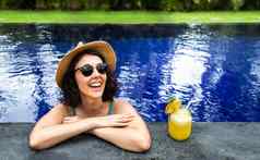快乐女人放松游泳池夏天假期热带度假胜地女假期饮料汁