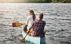 行成长年轻的夫妇独木舟骑湖