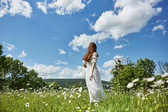 女人长光衣服站洋甘菊场持有手<strong>清晰</strong>的<strong>清晰</strong>的天空