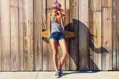新鲜的事情太阳年轻的女人挂木板路滑板