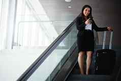聪明的应用程序不可或缺的现代业务旅行者女商人移动电话旅行自动扶梯机场