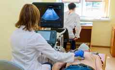 医生进行超声波检查病人的腹部诊所