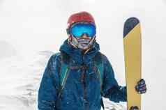 快乐滑雪站山滑雪持有滑雪板相机背景雪谷