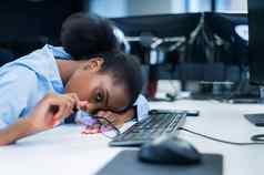 非洲年轻的女人睡觉工作桌子上