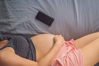 怀孕模型应用程序移动怀孕在线孕妇应用程序怀孕了妈妈。电话模拟怀孕医学制药学健康护理人概念图片