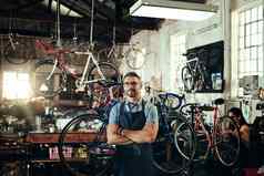 奋斗提供优越的自行车修复服务肖像成熟的男人。工作自行车修复商店同事背景