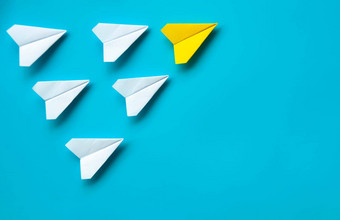 前视图纸飞机黄色的纸飞机折纸领先的白色飞机蓝色的背景领导概念