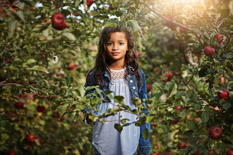 苹果果园使很酷的藏身地隐藏寻求肖像年轻的女孩站树叶苹果果园