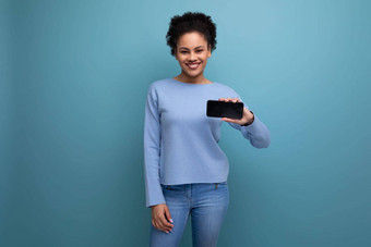 年轻的浅黑肤色的女人黑皮肤的皮肤女人持有智能手机水平模型网络页面