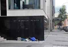 悉尼澳大利亚4月储备银行澳大利亚马丁的地方黑色的花岗岩墙悉尼澳大利亚无家可归的人男人。睡觉附近的