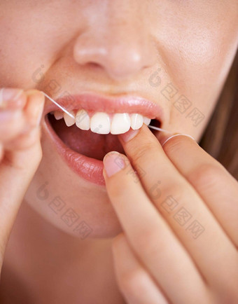 采取护理牙齿特写镜头拍摄年轻的女人用牙线清洁牙齿牙齿