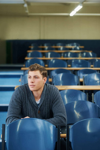 学生讲座大厅年轻的男人。坐着讲座大厅